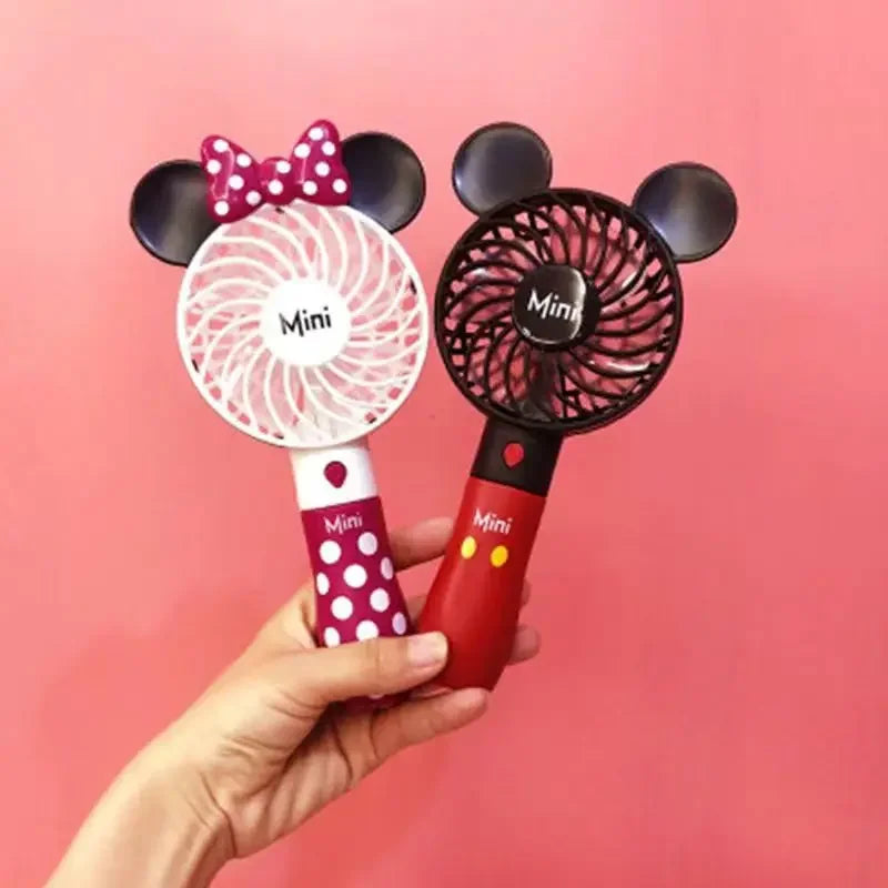 a person holding a minnie mouse fan and a minnie mouse hair dryer