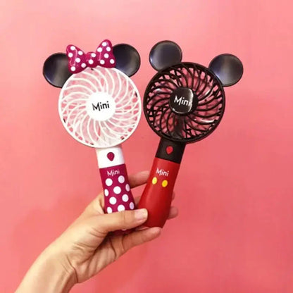 a person holding a minnie mouse fan and a minnie mouse hair dryer