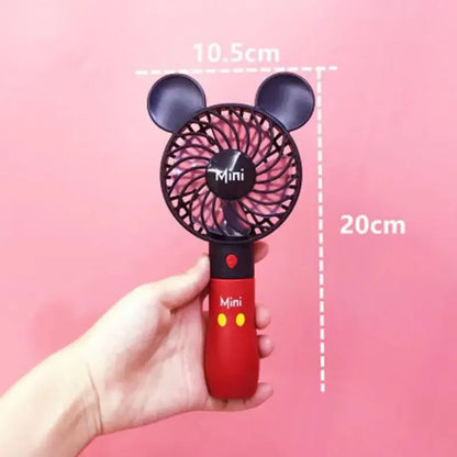 a hand holding a red and black mini fan